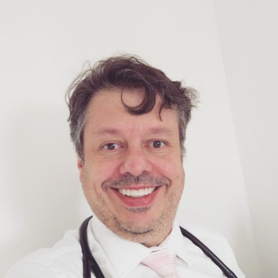 De jaleco e estetoscópio, sorrindo, em 2020